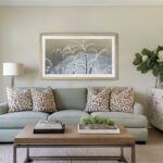 A 50-inch framed TV displaying elegant botanical art above a contemporary sofa, demonstrating how the warm oak wood effortlessly ties together soft, transitional room aesthetics.