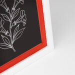 EventFrame white picture frame with a sage green accent line resting on a wooden shelf in a boho-style living room, highlighting a botanical print in a popular 8x10 size.