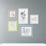 A warm, cozy bedroom featuring an EventFrame white wood frame with a soft pink inner line on a nightstand. The table stand option makes it perfect for personal family photos.