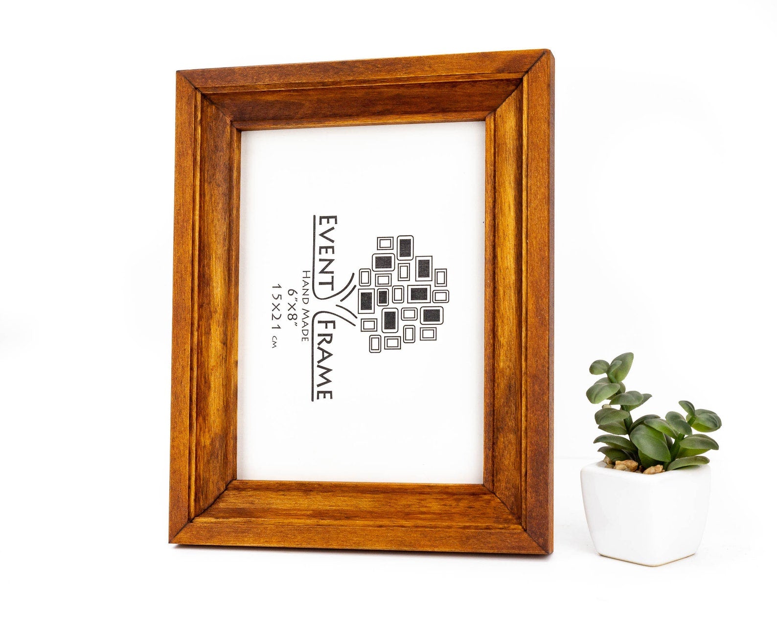 Wooden picture frame with a white background and text, next to a small potted plant.Honey Brown Wooden Picture Frame, Gallery Wall Birch Hardwood Frame, Handmade Premium Quality, Custom Size A4, A3, 6x8, 10x12, 18x24, 20x30
