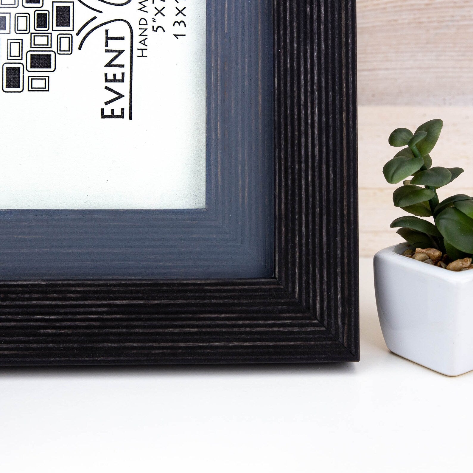 Black picture frame with 'Event' branding on a white surface with a plant in the background. Black + Grey Handmade Picture Frame, Photo Frame with Wooden Mat, Two Tone Poster Wall Frame, Custom Sizes A1 A2 5x7 8x10 18x24 24x36 20x30
