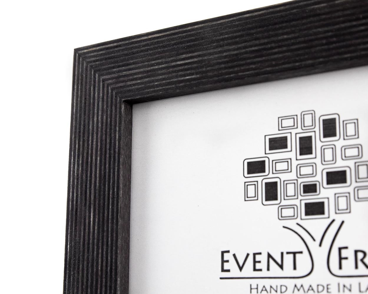 A black solid birch hardwood picture frame with a unique stripy design, displayed with a small potted plant to the side.