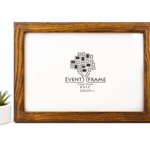 A brown oak hardwood picture frame with a visible brand logo, placed on a white surface next to a potted plant. Brown Oak Wood Picture Frame, Rustic Oak Photo Frame, Custom Photo Frame for Wall Art A4, A2, 5x7, 8x10, 8.5x11, 9x12, 10x14, 11x17, 16x20